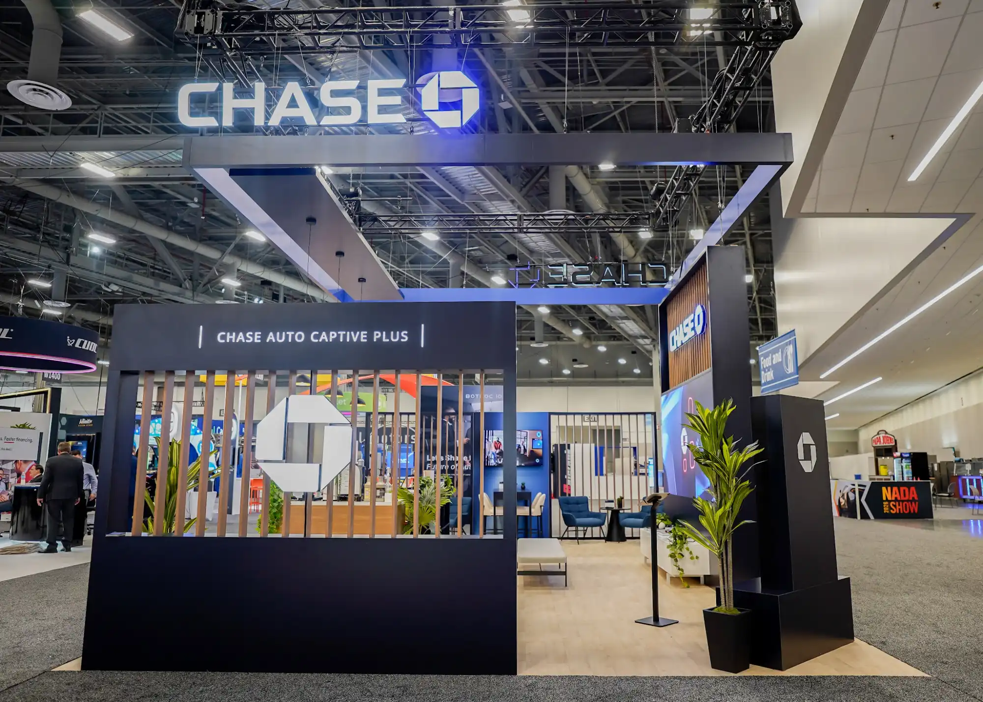 Chase Auto booth overhead truss structure with integrated blue and white LED lighting, Captive Plus entrance branding