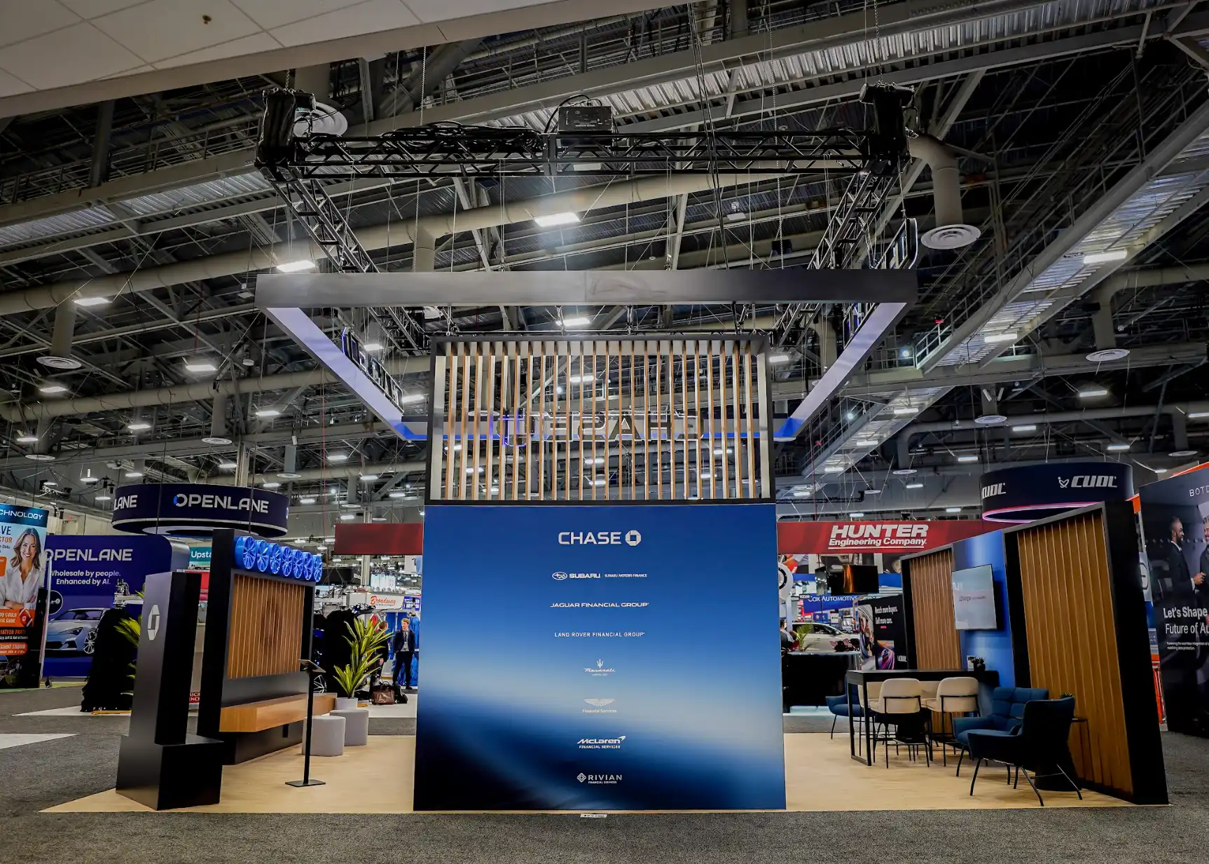 Chase Auto island booth at NADA Show 2026 seen from the show floor with illuminated corner pylons marking the entry points