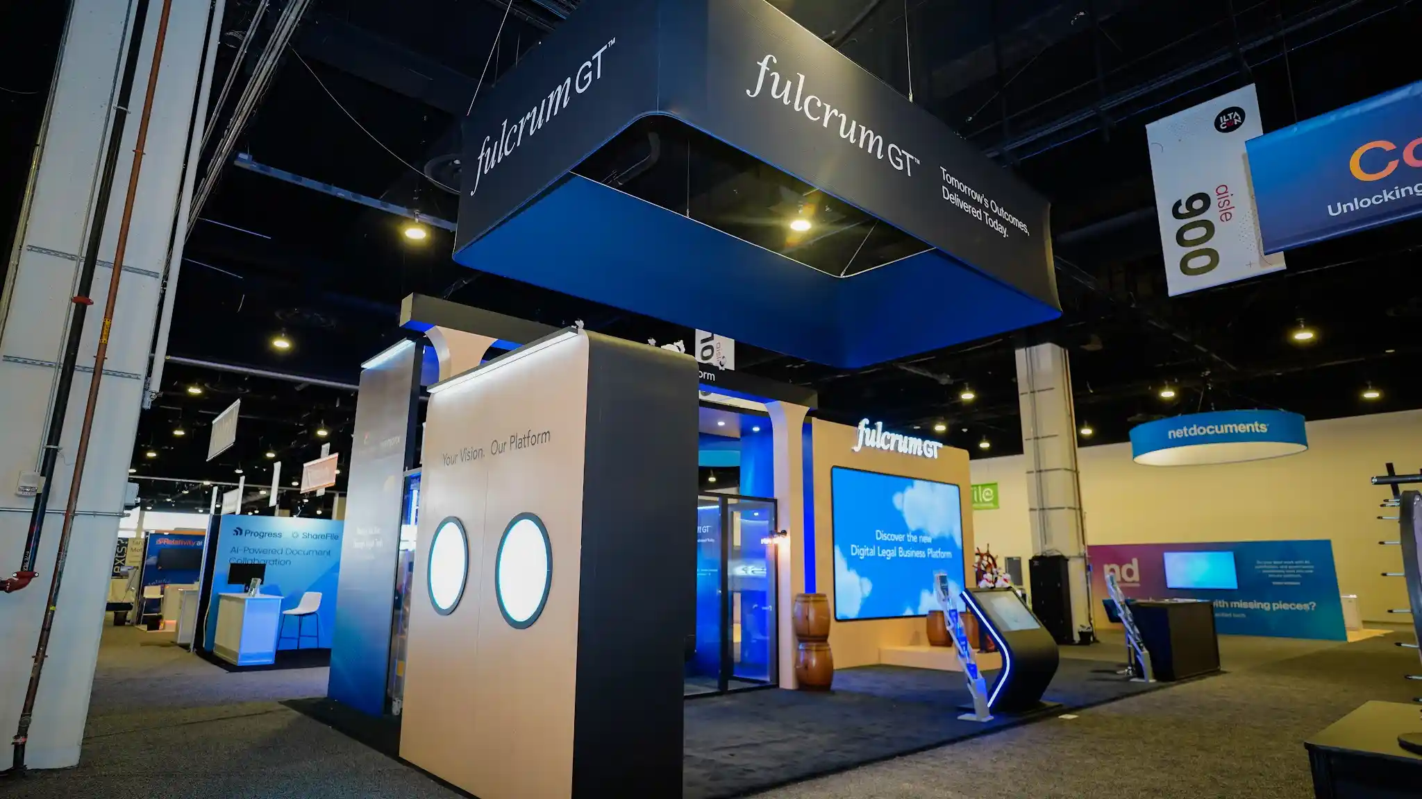 Digital platform screen showing Discover the new Digital Legal Business Platform with mobile interface, angled touchscreen kiosk, porthole wall with circular cutouts, and Your Vision Our Platform messaging