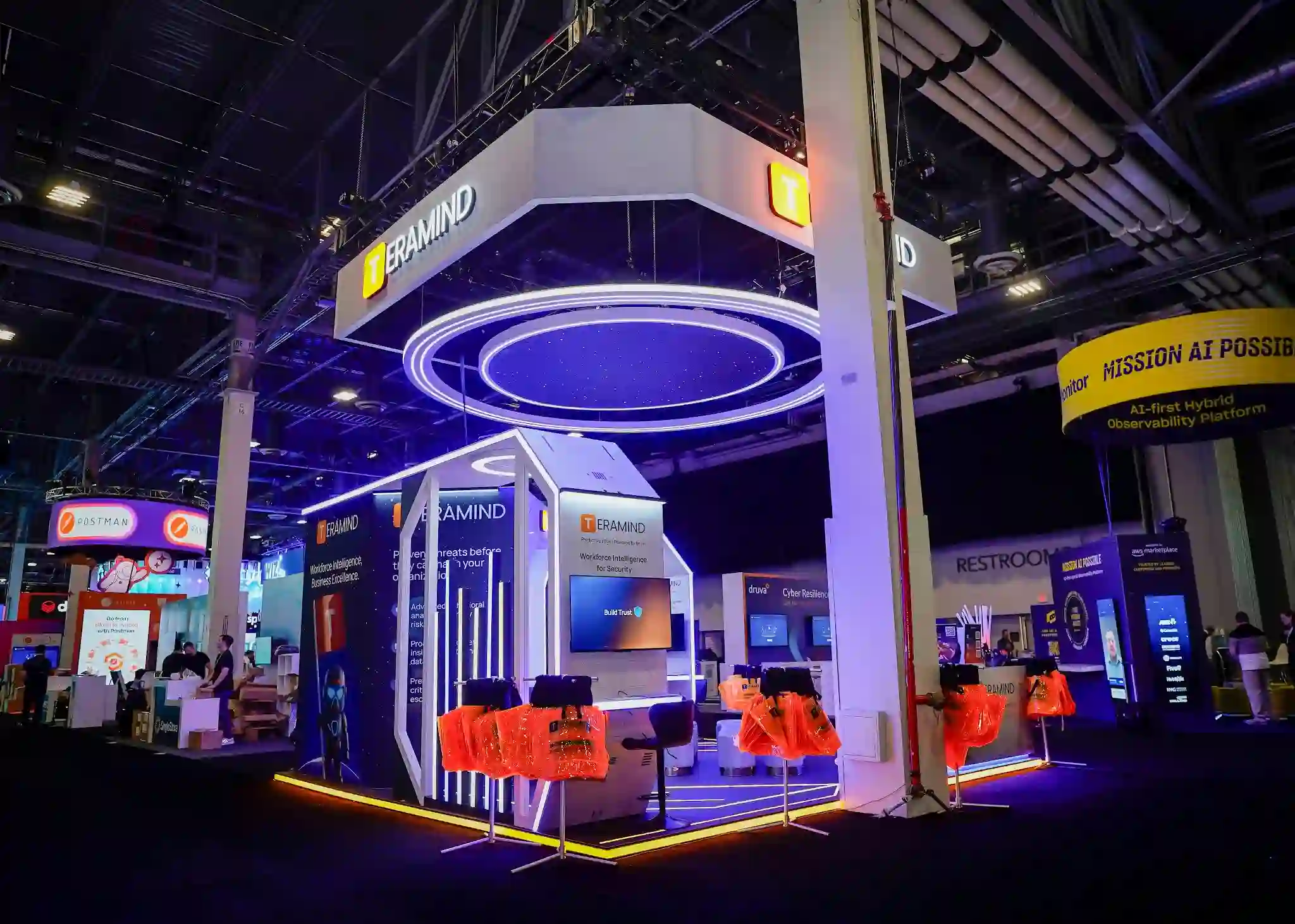 Full booth view from distance showing complete island layout, LED lighting, and positioning within expo hall