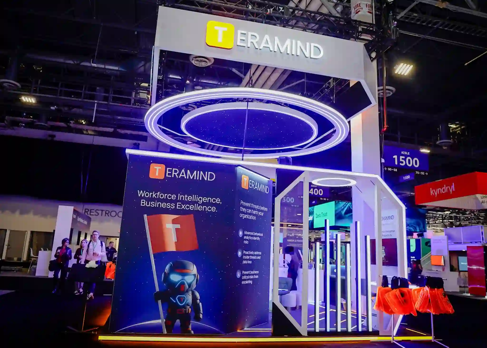 Teramind booth graphic wall featuring futuristic character illustration in deep-blue space theme with Workforce Intelligence Business Excellence messaging and Teramind logo