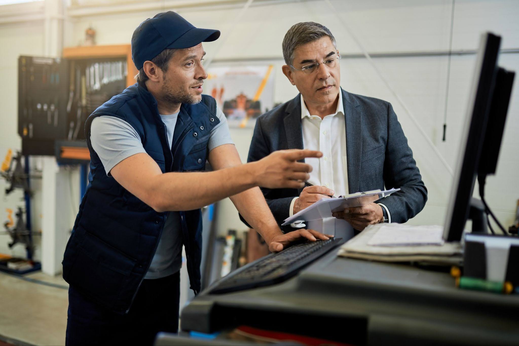 exhibition service — Pure Exhibits team member reviewing booth design plans with client before Las Vegas trade show exhibition service — Pure Exhibits team member reviewing booth design plans with client before Las Vegas trade show