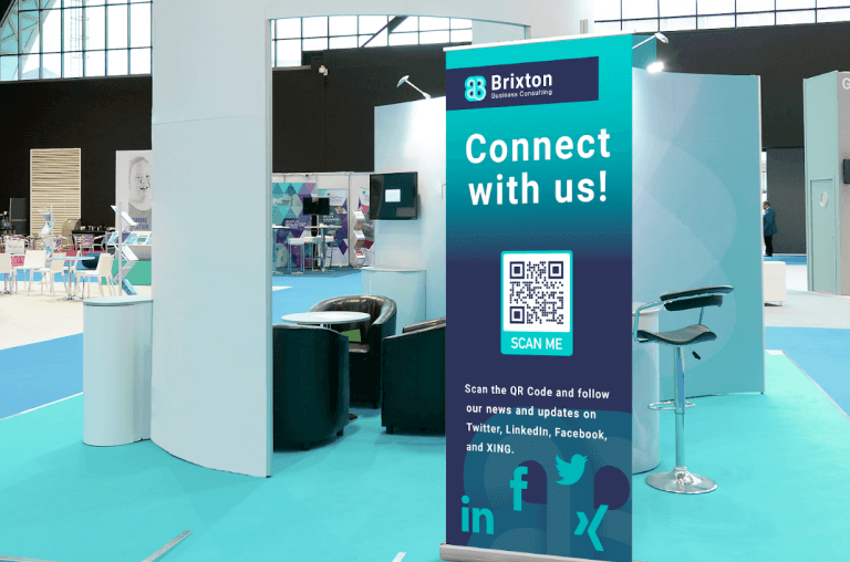 trade show booth qr codes — exhibitor pointing to qr code on back wall display at Las Vegas convention booth for visitor to scan