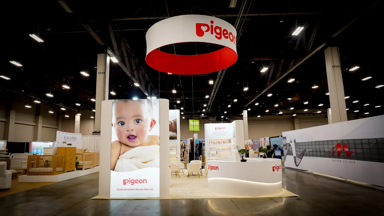 Pigeon product universe display at ABC Kids Expo 2026 featuring comprehensive interactive shelving across feeding bottles, nipples, baby skincare, oral care and maternity products organized by developmental stage with clear brand-consistent labeling and accessible product interaction zones for trade show buyers