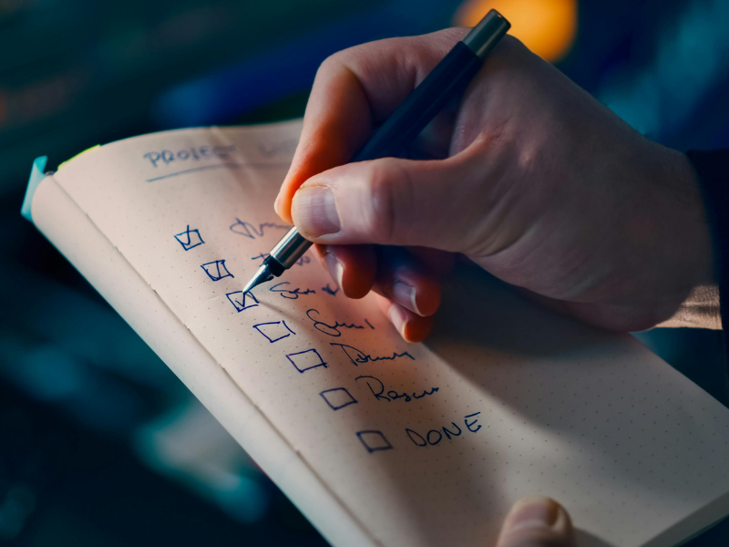 Checklist.png a man checking off tasks from trade show checklist for exhibitors