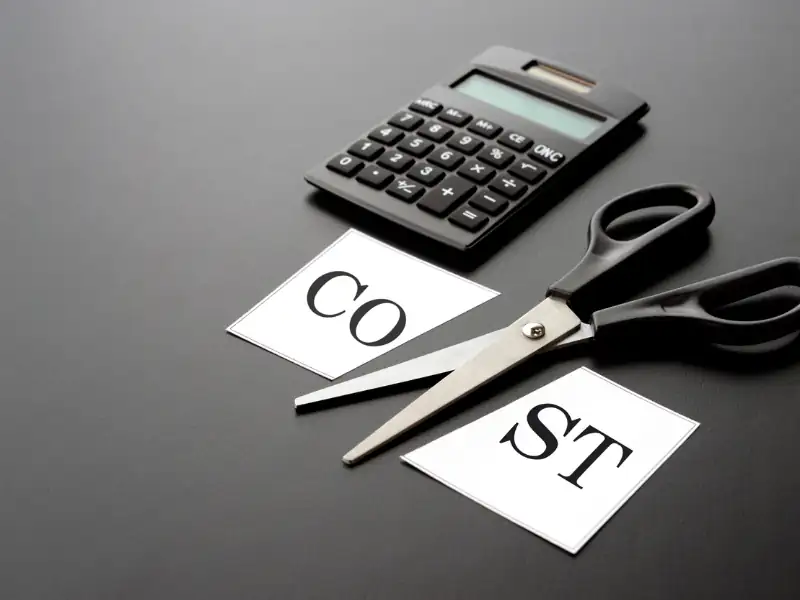 COST.png A symbolic image showing how to cut trade show expenses by cutting cost written on paper with a scissor
