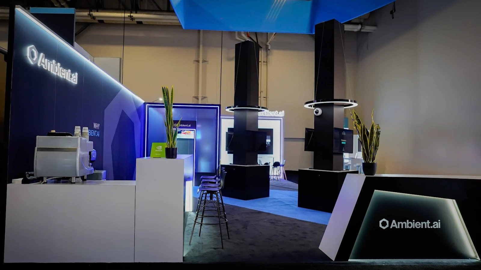 Ambient.ai modern black and blue exhibit at ISC West 2026 showing the display-led structure and open perimeter of the island booth