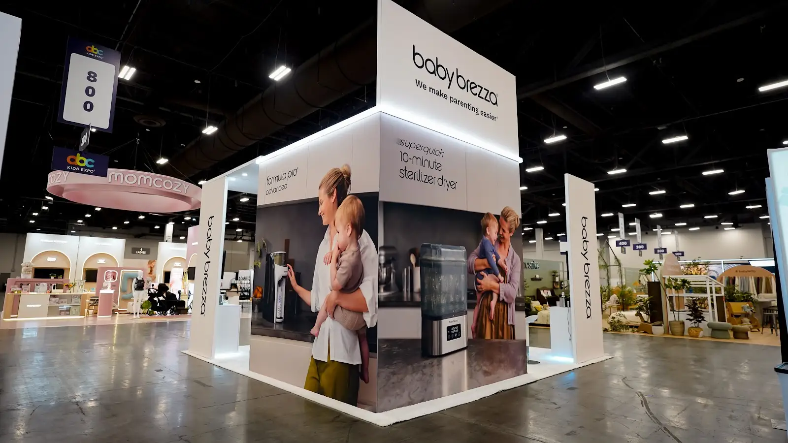 Baby Brezza island booth at ABC Kids Expo 2026 showing the open layout designed for retail buyer meetings and product demonstrations