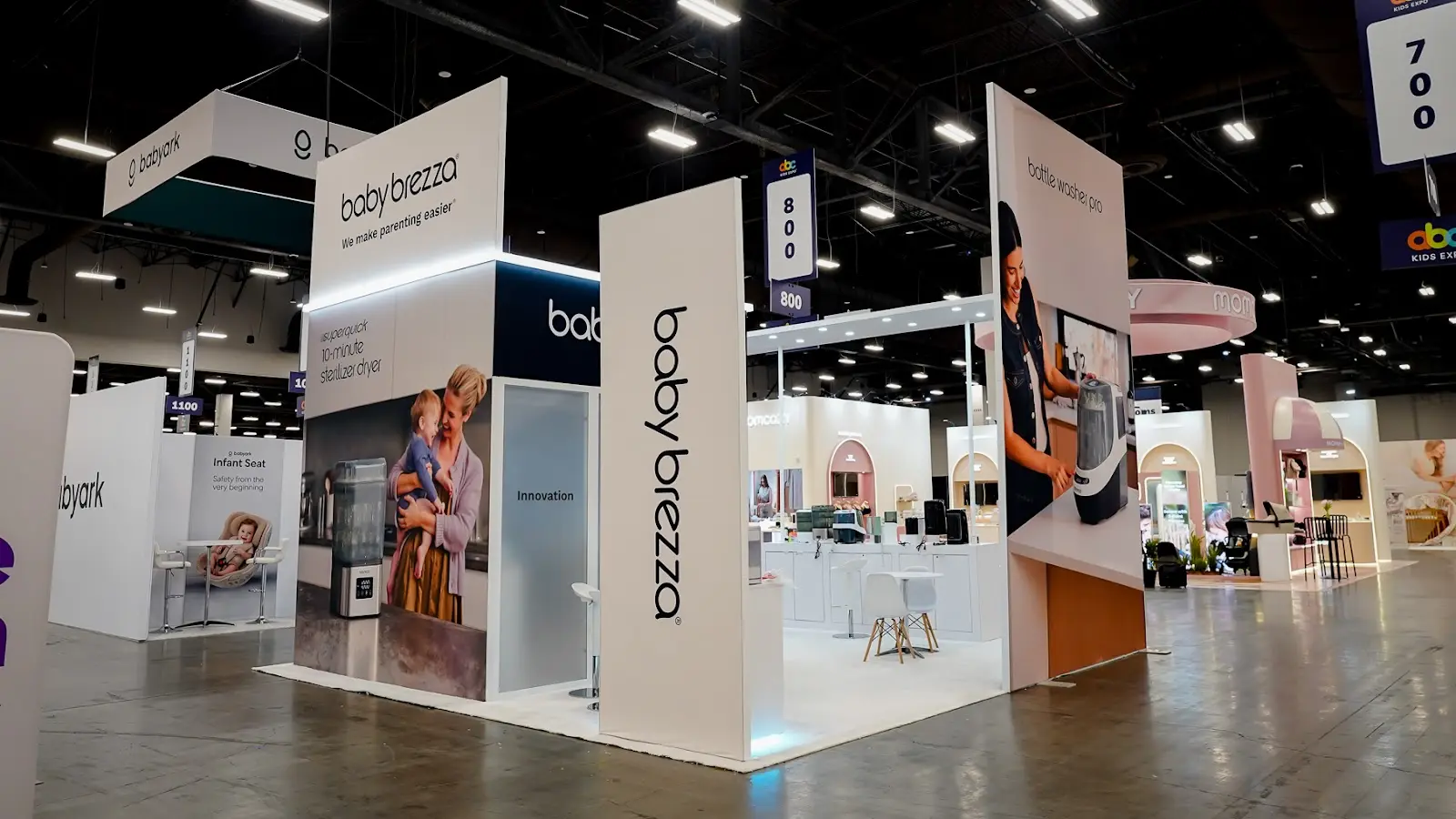 Baby Brezza island trade show booth at ABC Kids Expo 2026 photographed from the corner of the aisle at Mandalay Bay