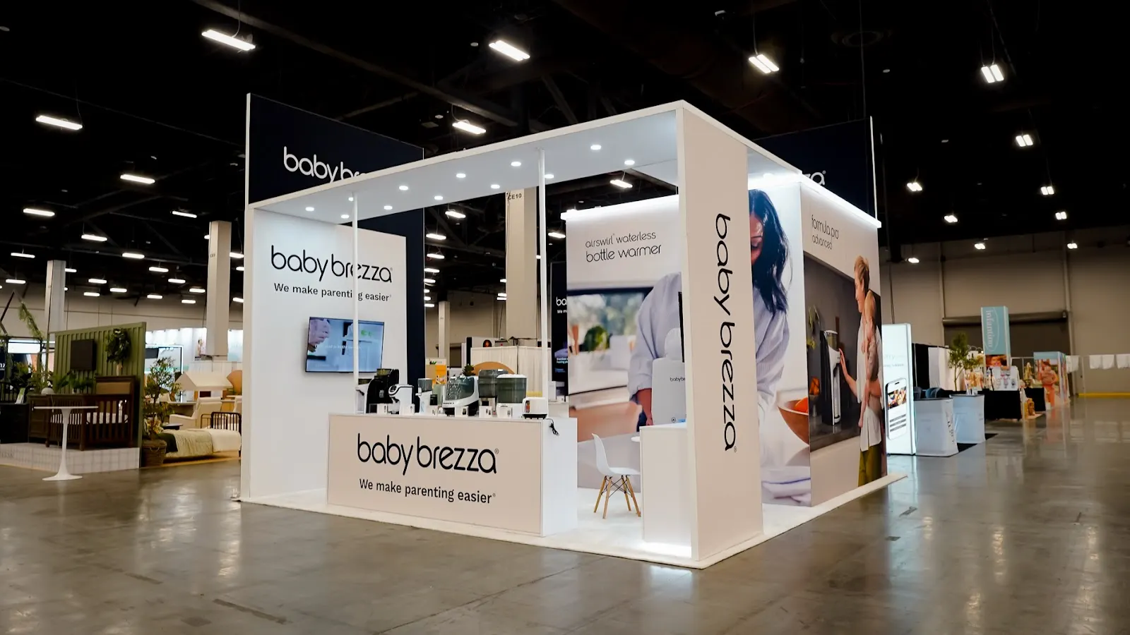 Baby Brezza white custom island booth at ABC Kids Expo 2026, viewed from the aisle at the Mandalay Bay Convention Center in Las Vegas