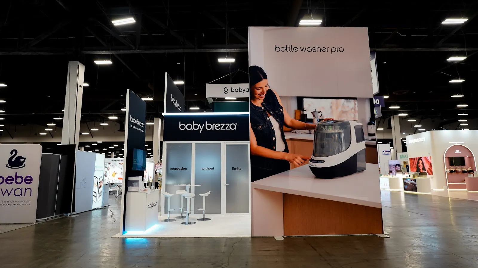 Further view of the Baby Brezza island exhibit at ABC Kids Expo 2026 showing the full white structure in context on the show floor