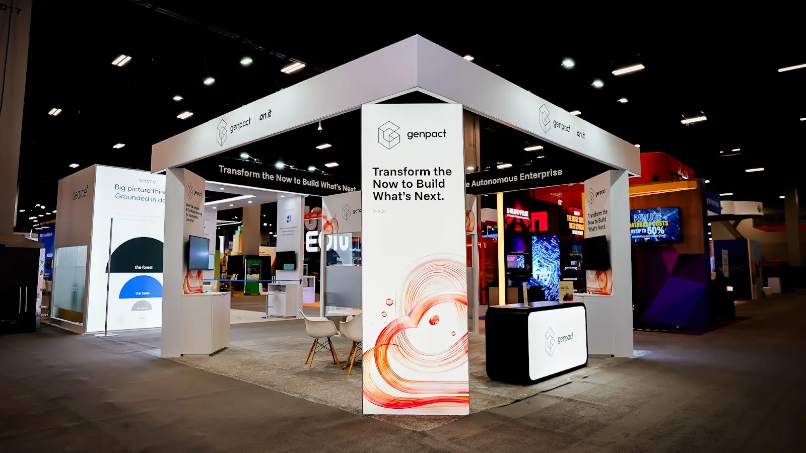 Genpact custom island booth at Google Cloud Next 2026, viewed from the aisle at the Mandalay Bay Convention Center in Las Vegas
