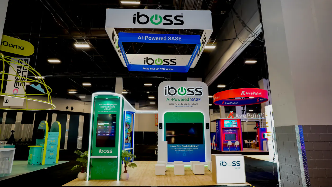 iboss AI-Powered SASE 20x20 island booth at Black Hat USA 2026 with a square hanging sign, backlit theater screen wall, green AI kiosk and white cube seating